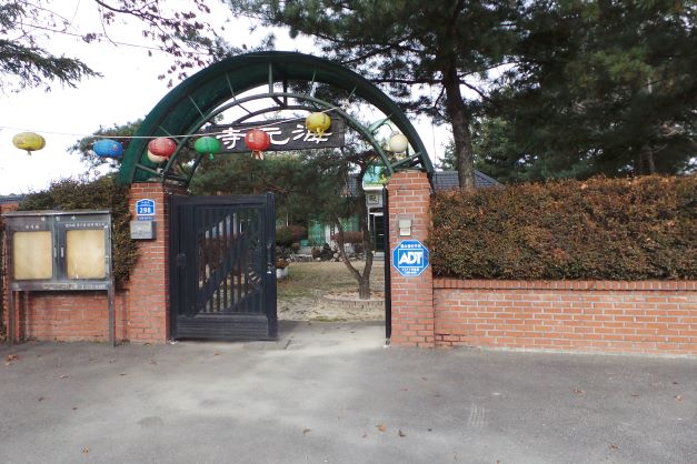 해인사 정문, 철문 하나만 열려 있음, 한족은 닫려 있고, 아치형 문에 걸린 연등,