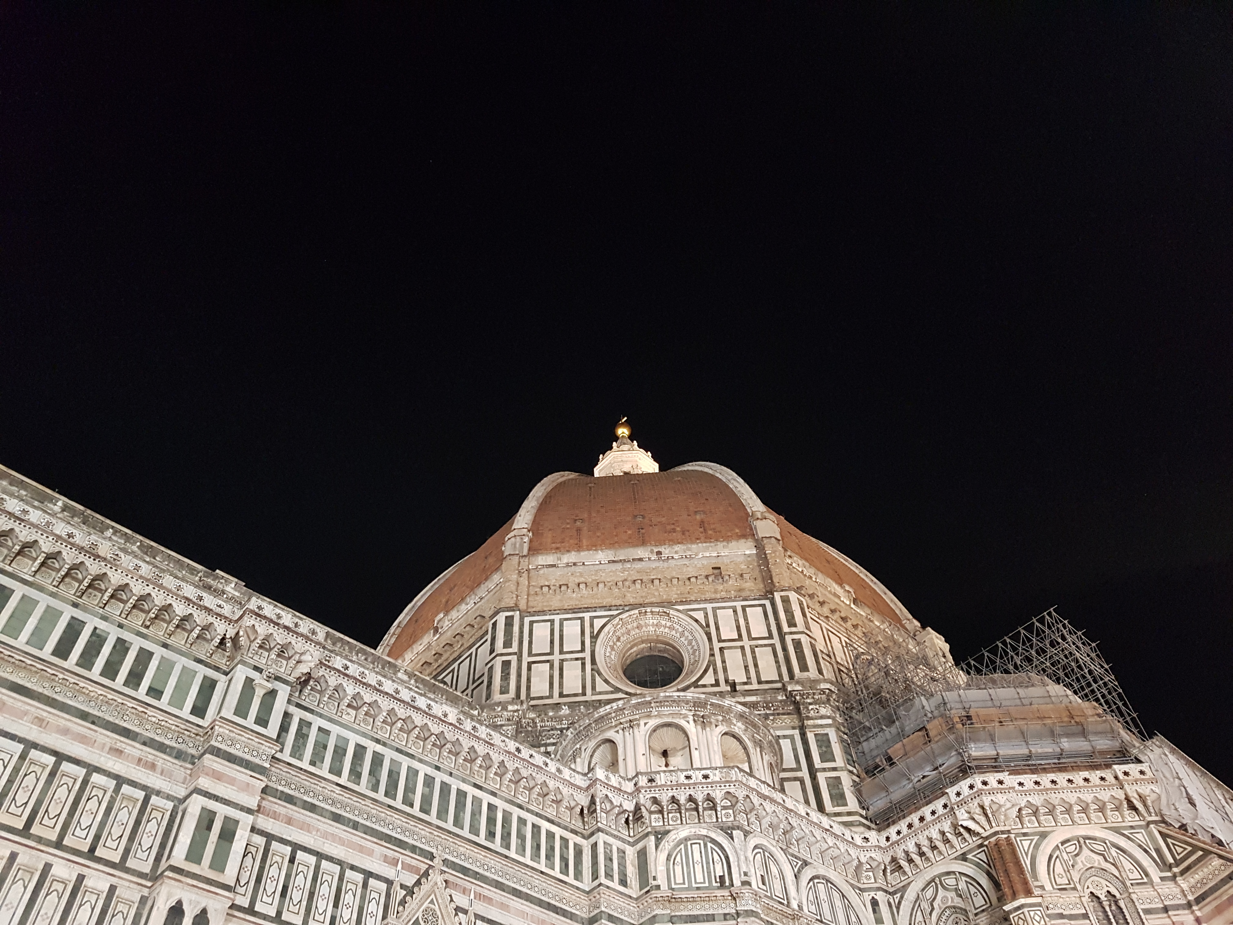 어두운 밤하늘 아래 조명을 받아 빛나는 브루넬레스키의 두오모 돔 근접샷