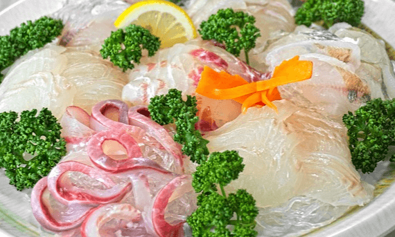 넓은 하얀 접시에 하얀 광어회와 초록색의 파슬리들이 장식돼 있다.