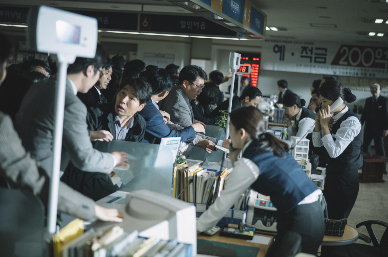 외환위기 당시 은행 창구에 사람들이 몰려들어 혼란스럽게 붐비는 장면, 직원들도 분주하게 움직이고 있다