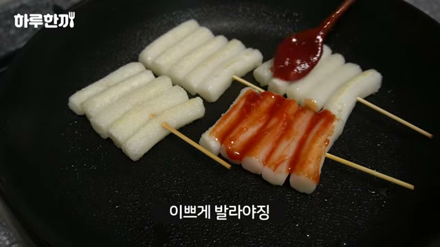 떡 꼬치에 양념을 바르는 장면