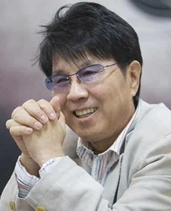 조용필이-스트라이프-셔츠와-아이보리색-재킷을-입고-두-손을-깍지-낀채-미소를-띄고-있는-사진