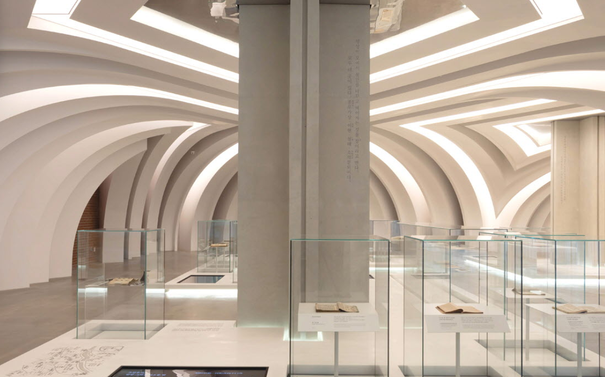 서소문성지 역사박물관 내부 하얀색 아치형 기둥과 유리 진열장이 있는 전시실 전경