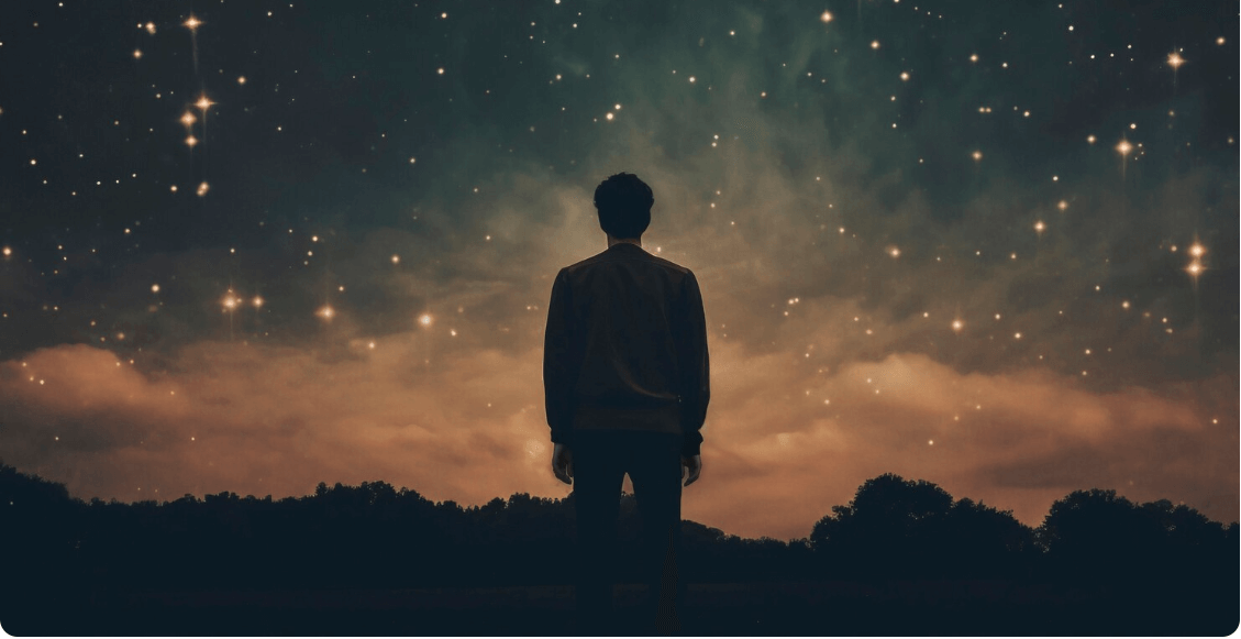 해질 녘에 산에서 하늘을 바라보고 있는 남성