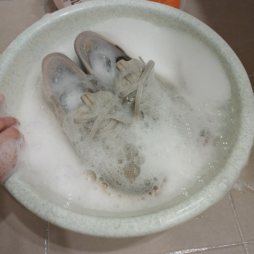 중성세제와 과탄산소다를 푼 미지근한 물에 흰 운동화를 담근 과정