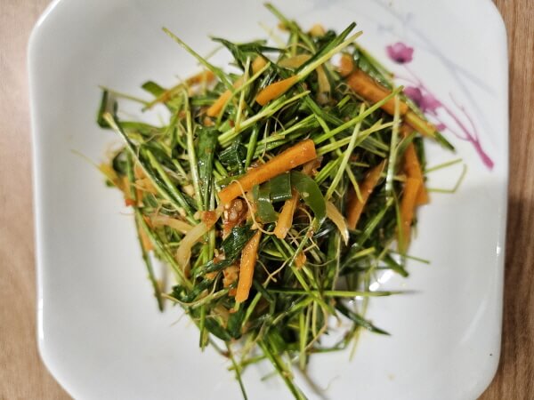 접시에 담긴 새싹보리 겉절이 무침