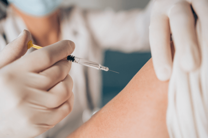 의료진이 주사기로 독감 예방접종을 하는 장면