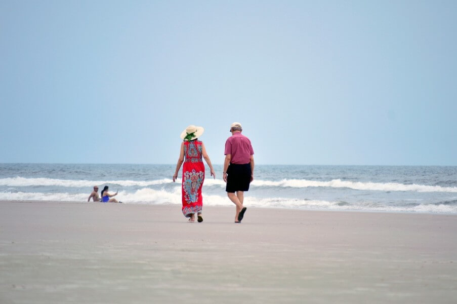 백사장을 걷고 있는 노부부