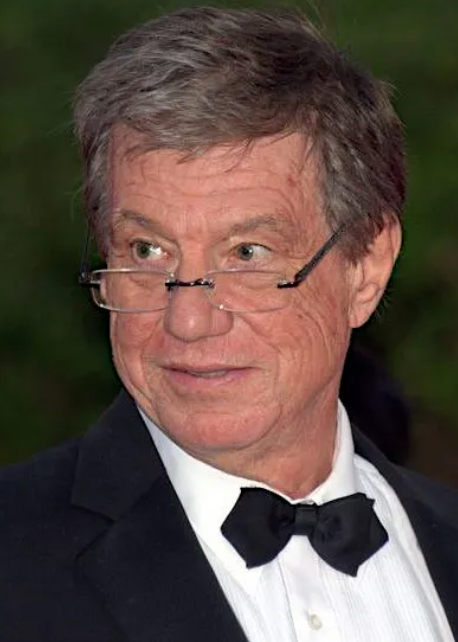 안경쓰고 턱시도 입고있는 존 탬벨맥티어넌 주니어 감독사진