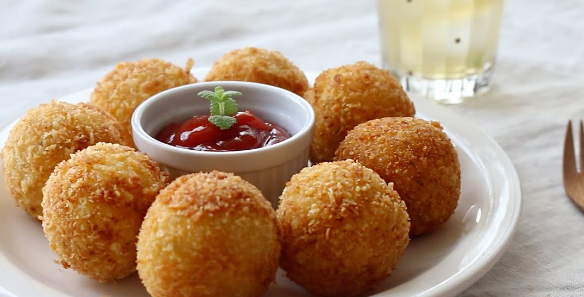 노르스름한 공 모양의 감자볼이 흰색 접시위에 놓여져 있다.