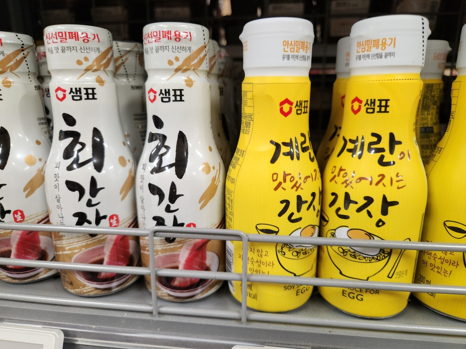 마트 진열대에 노란 포장의 간장이 여러 개 올려져 있다