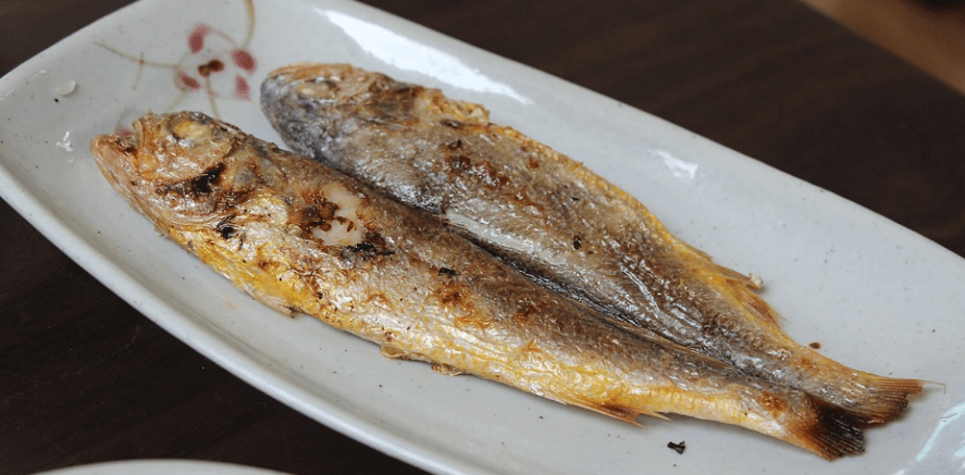 맛있게 구워져 있는 조기 두마리가 접시에 담겨 있다
