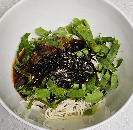 두유면 위에 매운 소스, 김가루 , 깨, 아삭이 상추를 올린 모습