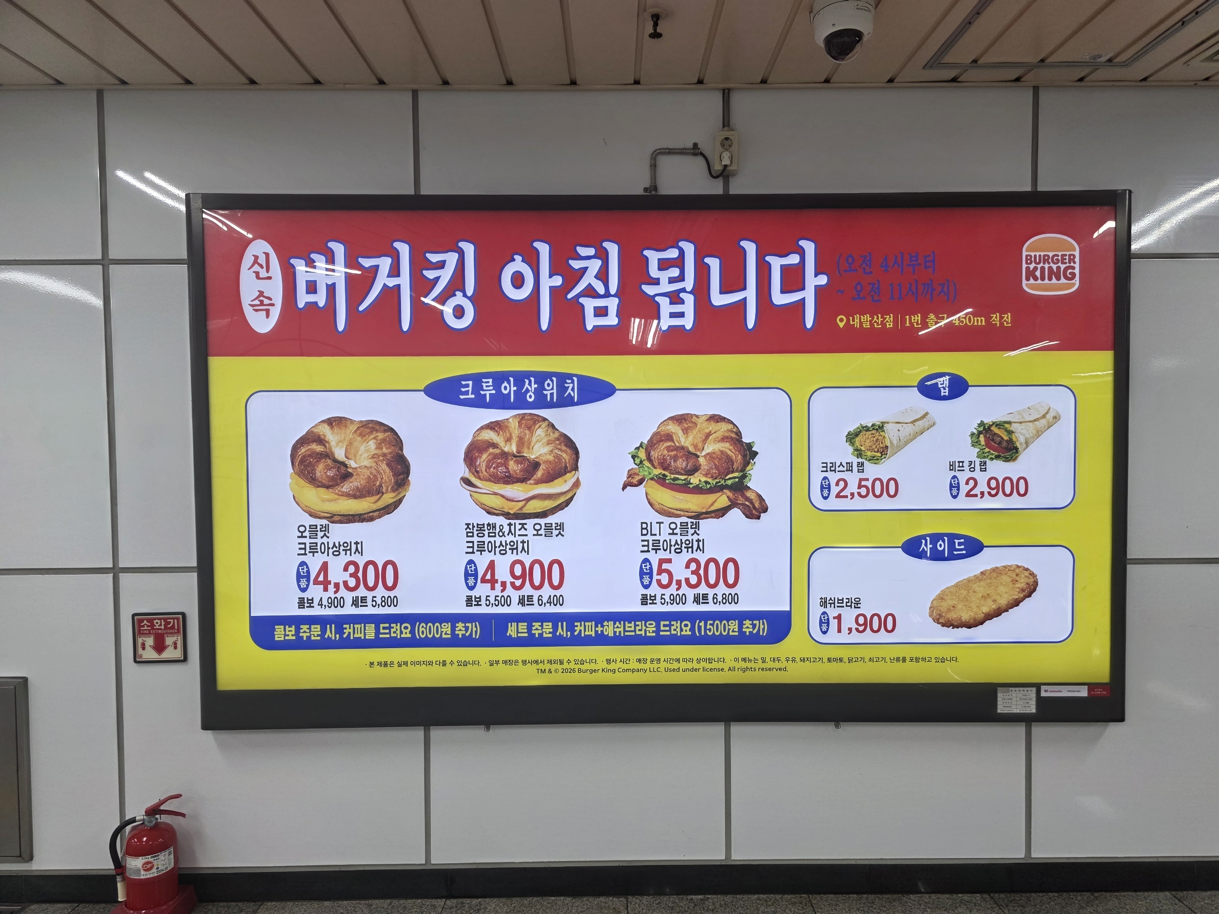 지하철역 벽면 대형 광고판에 &lsquo;버거킹 아침 됩니다&rsquo; 문구와 크루아상위치 메뉴 및 가격이 표시된 모습