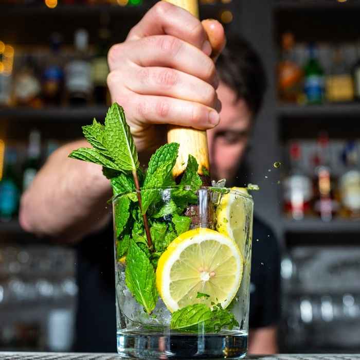 머들러를 이용해 민트와 레몬을 으깨는 제조 과정