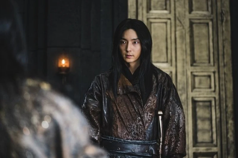 웅장한 궁전을 배경으로 검붉은 비단옷에 긴 머리를 내려트리고 있는 드라마 아라문의 검의 사야 캐릭터