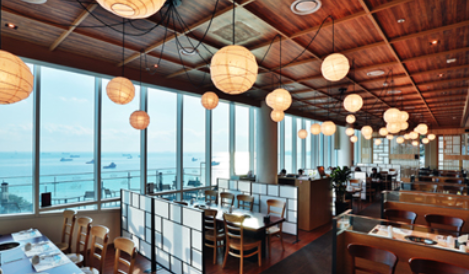 테이블이 있는 식당 외부 바깥 창문으로 바다가 보인다