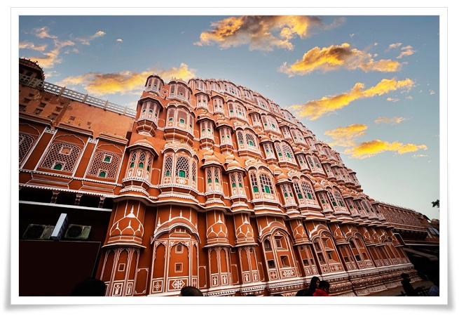 붉은색과 분홍색 색채의 외벽에 하얀색의 수많은 창문 테두리에 문양이 그려져 있는 벌집 모양의 거대한 궁전 전경