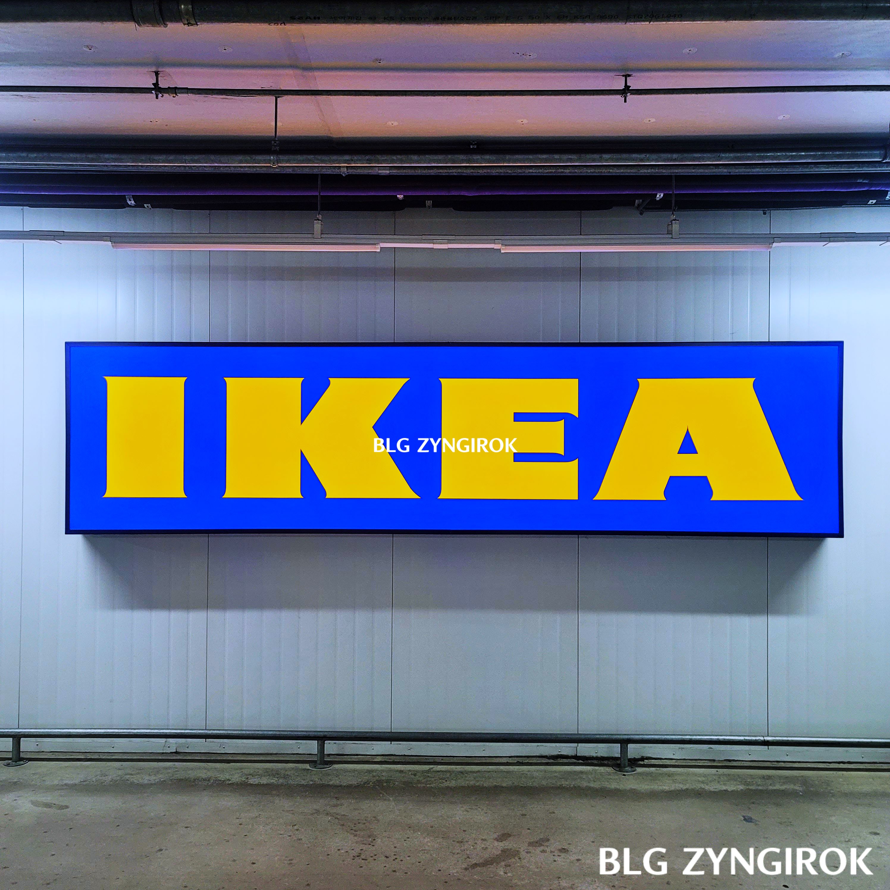 지하-주차장에-걸려있는-이케아-글씨-간판이다.-파란-사각형에-노란색으로-이케아가-쓰여있다.