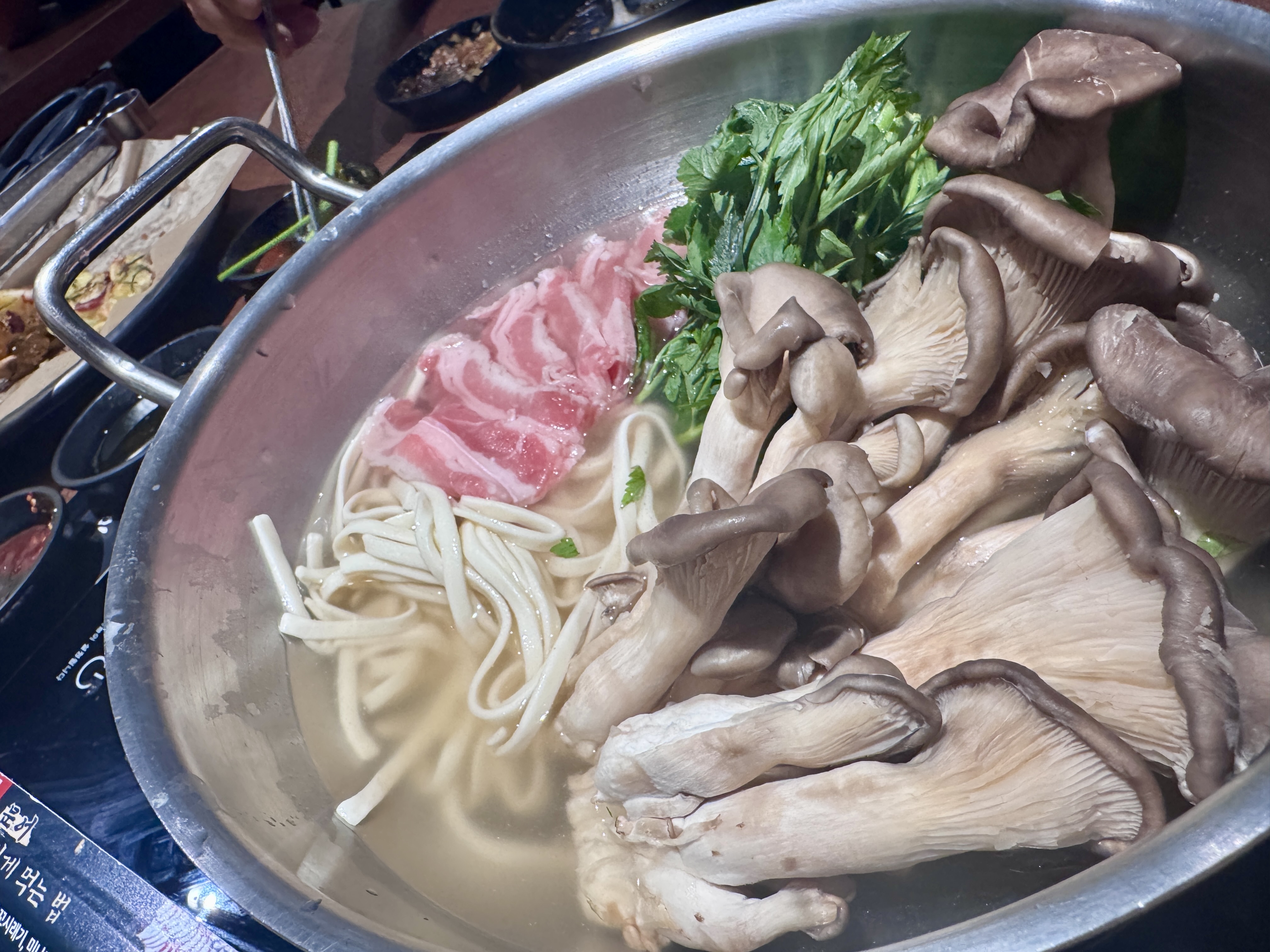 광교 석문어 미나리 소고기 칼국수. 순한 육수에 칼국수 면과 소고기, 버섯, 미나리가 푸짐하게 들어간 모습