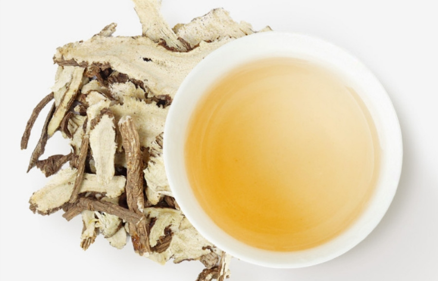 야생에서 채취를 한 당귀를 깨끗하게 세척을 하고 편으로 썰어 놓은 것을 하얀 바닥 위에 놓아두고 그 옆에는 희고 동그란 그릇에 당귀를 끓여서 만든 차를 담아두고 찍은 사진