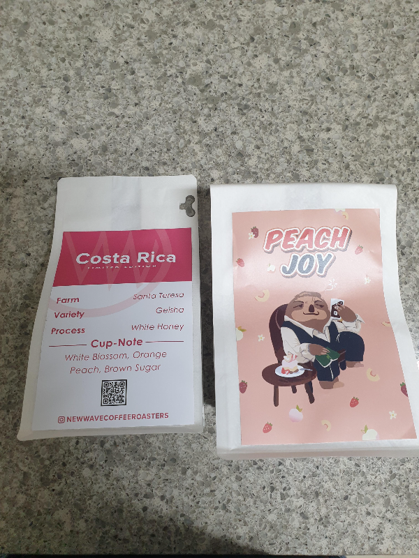 테이블 위에 원두 패키지 두 개가 올려져 있다. 하나는 코스타리카 다른 하나는 PEACH JOY 블렌드 원두다
