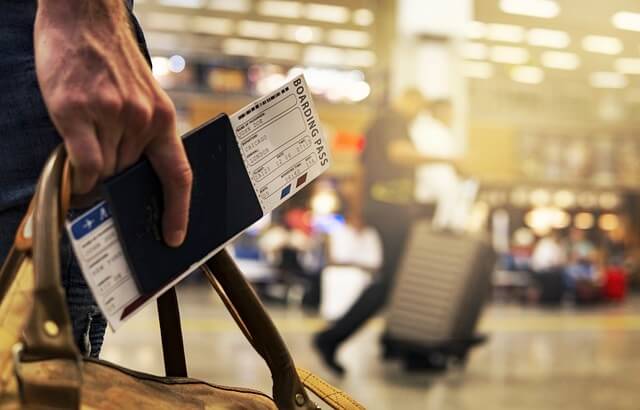 가방_여권_비행기표를 들고 있는 손