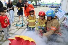소방관-아저씨가-어린이-들에게-불끄는-시범을-보여주는-모습