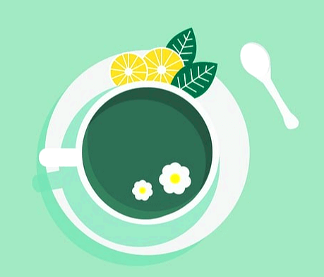 하얀 잔에 녹색의 차가 들어있다. 주변엔 노란 레몬조각 2개가 이다.