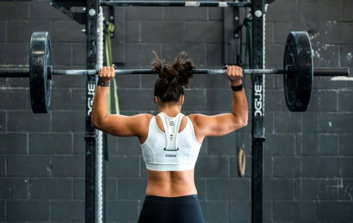 무거운 바벨을 들고 운동을 하고 있는 여성