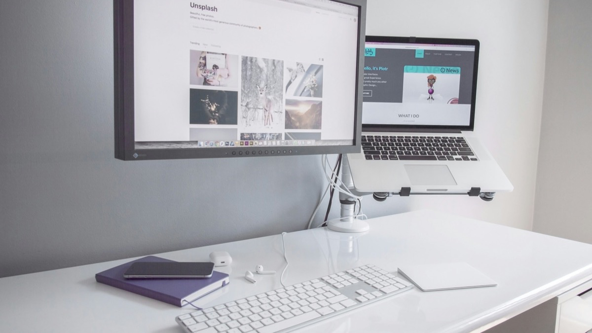 책상 위 MacBook과 외장 모니터가 케이블로 연결된 실제 작업 환경