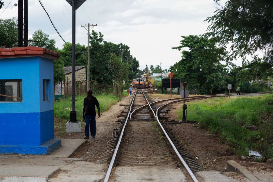 A rural railway scene featuring tracks, a switch, and a guardhouse in a verdant landscape.