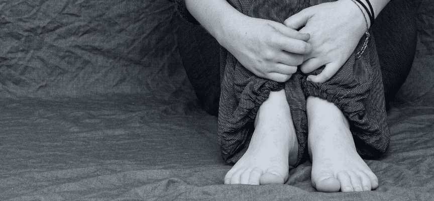 손과 발을 모으고 쪼그려 앉아 있는 여자