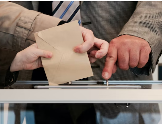 선거에서-투표용지를-투표함에-넣고-있다