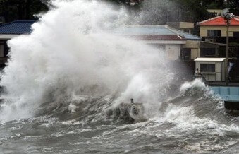 바닷가에-인접한-집으로-집체만한-하얀-파도가-몰아치는-모습