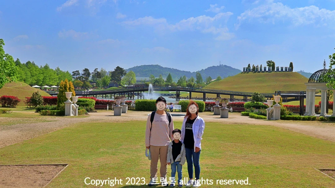 순천만국가정원 풍경으로 유럽풍 정원과 그 너머 언덕과 강이 보인다.