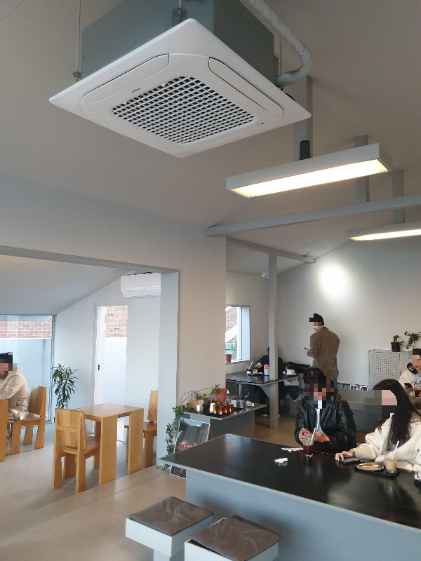 그레이화 화이트 인테리어 그리고 우드와 그레이 테이블들. 살마들이 꽤나 있다.