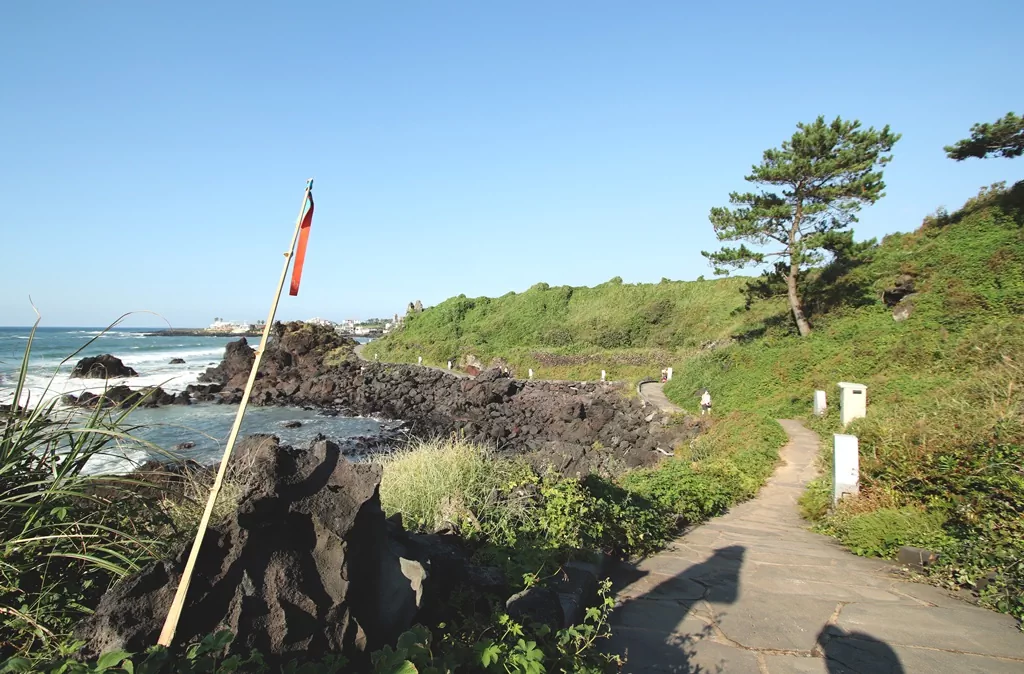 제주 올레길 15코스 곽지과물해안산책길의 한적한 해변과 부서지는 파도 소리가 들리는 듯한 평화로운 풍경.