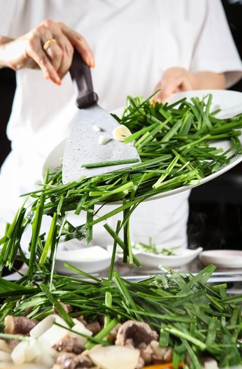 고기 요리에 부추를 추가하여 요리하는 사진