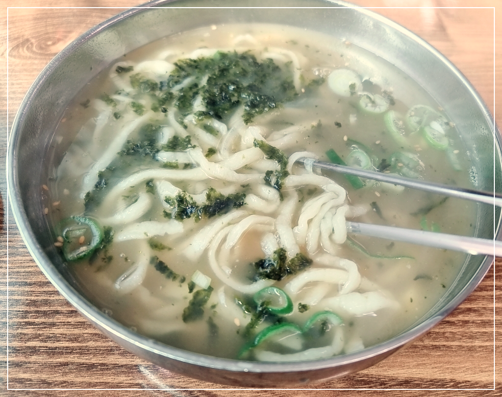 칼국수를 젓가락으로 살펴보고 있음