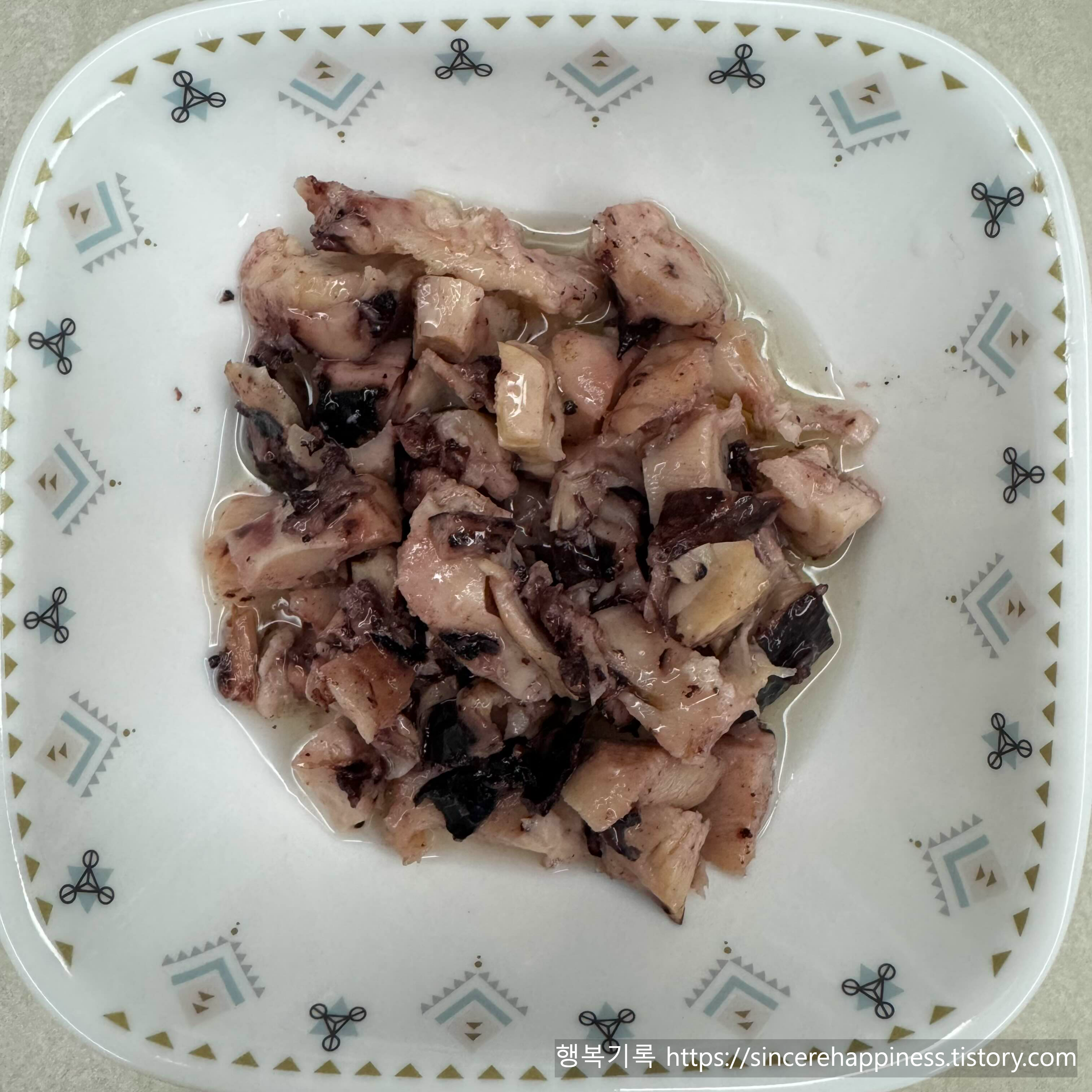 흰색 무늬 접시에 담긴 부드러운 식감의 트레이더조 칼라마리 올리브오일 절임