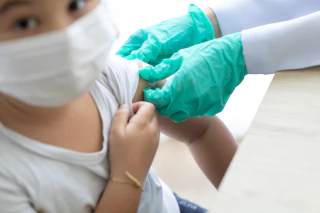 왼쪽 팔에 밴드를 붙이는 아이