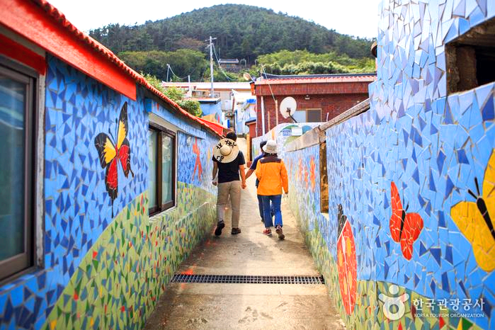 벽화 골목길에 사람들이 걸어가고 있다.