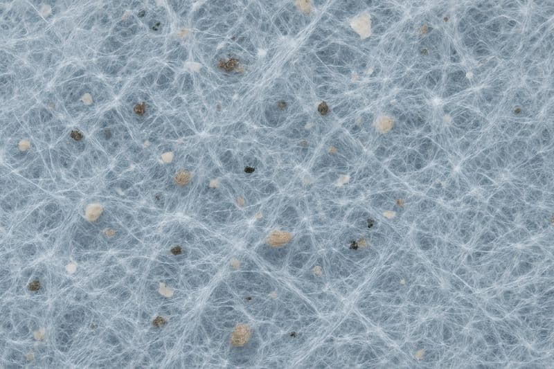 마스크 필터층의 복잡한 섬유 구조와 입자를 보여주는 클로즈업