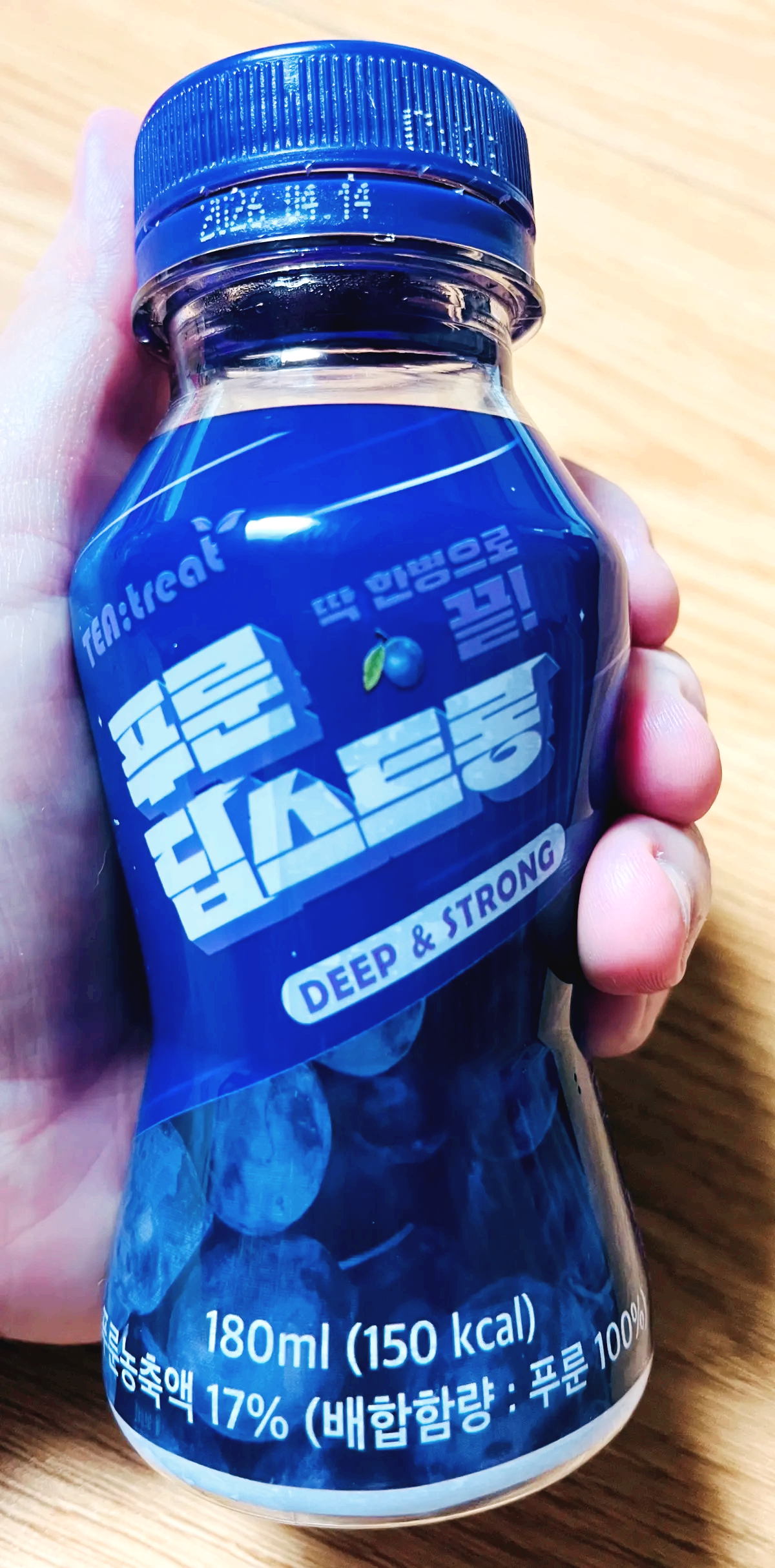 손으로 푸룬딥스트롱 음료를 들고 있는 모습