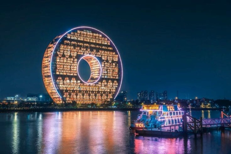 화려한 원형 LED 건축물이 강가를 밝히는 야경으로, 광저우의 미래적 랜드마크와 유람선이 어우러진 장면