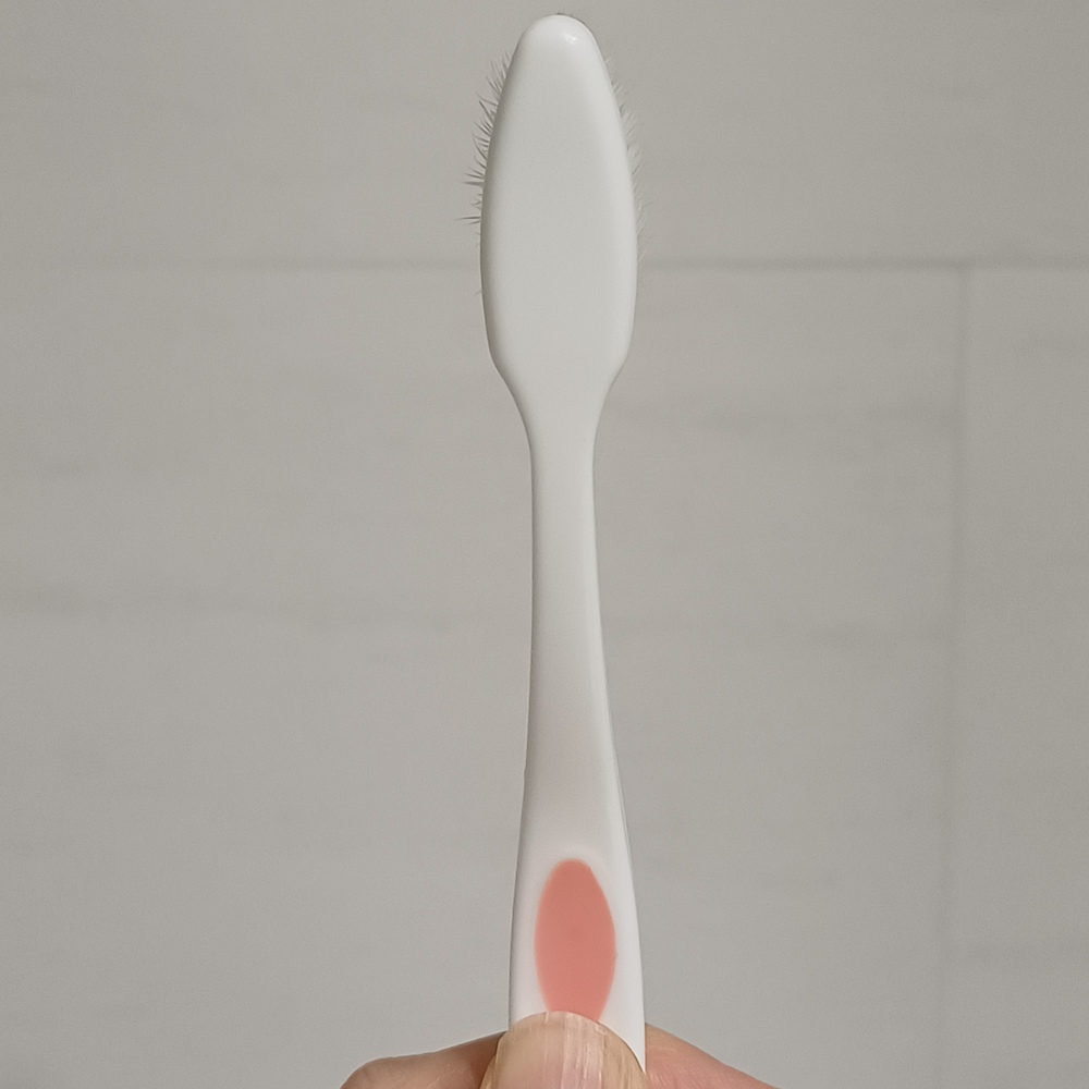 칫솔을 뒤집어 모가 벌어진 상태를 확인하는 모습