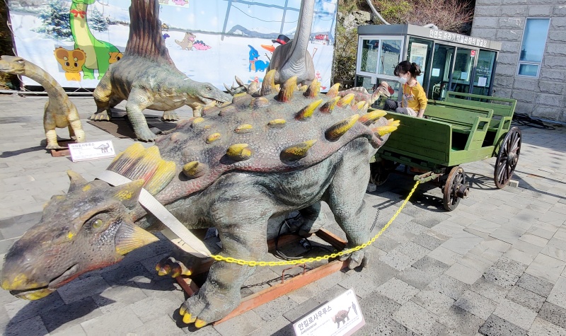공룡 조형물과 마차가 있는 포토죤