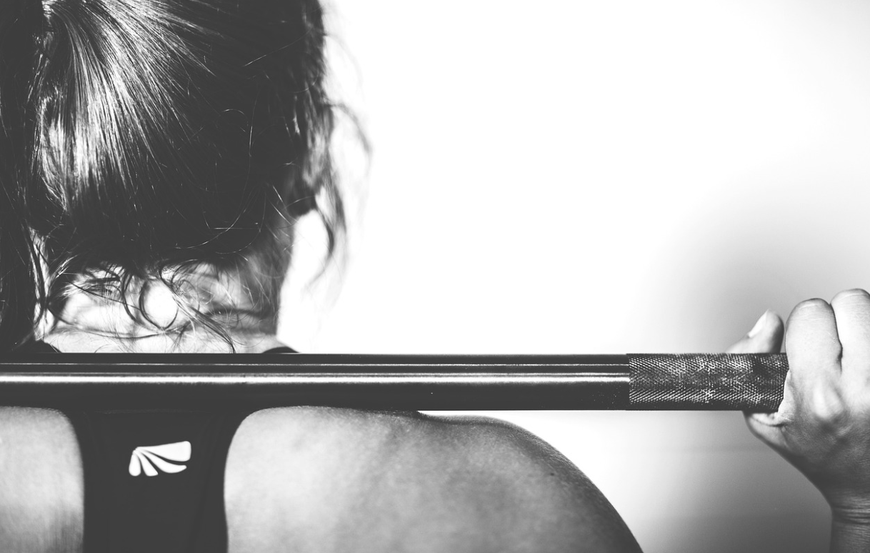 바벨을 쥐고 운동하고 있는 사람