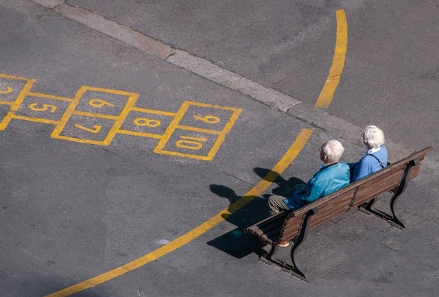 &ldquo;숫자가 적힌 놀이판이 그려진 바닥 앞 벤치에 나란히 앉아 있는 노인 두 명. 과거의 기억과 세월의 흐름을 상징하는 장면&rdquo;